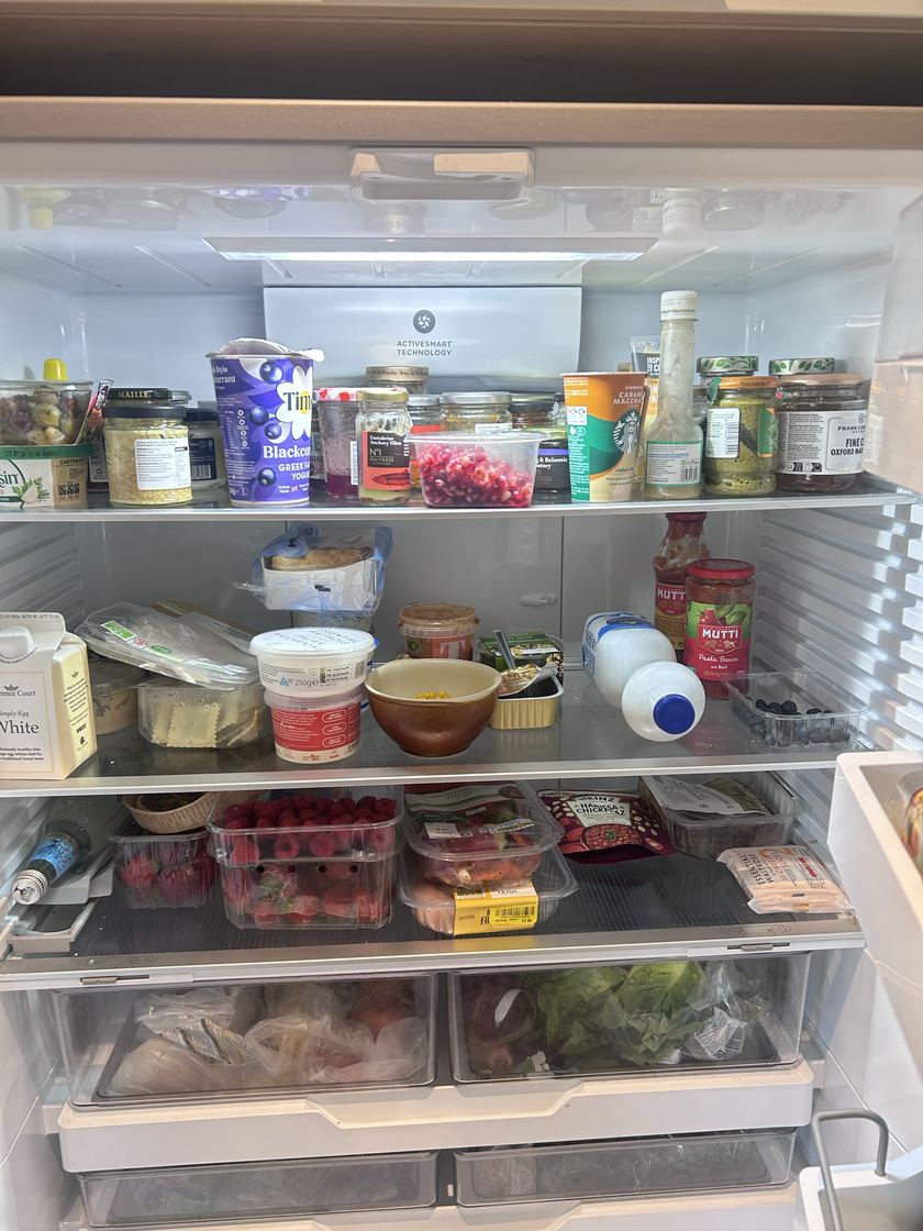 An honestly messy, real fridge — full shelves, brand labels, a reduced-price sticker